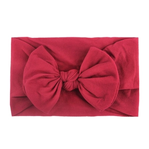 Soft nylon baby headband with a large dark red ribbed knit bow for infants