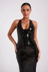 Detailed view of the 3D rose decoration on a black sequin backless evening dress
