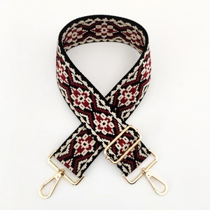 Close-up of ethnic jacquard wide strap with geometric patterns and gold metal hooks