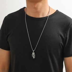 Détail du collier pendentif tête de mort argenté avec haut-de-forme sur un mannequin
