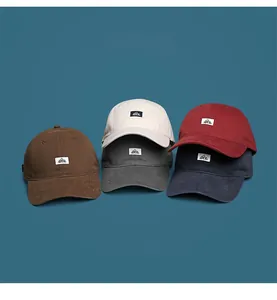Close-up detail of soft-top baseball caps in five classic colors with logo patch