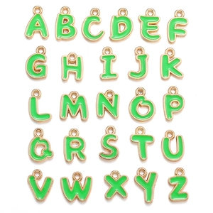 Detailed grid view of 26 green enamel alphabet charms with golden alloy edges