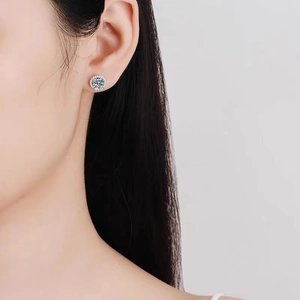 Close-up of a model wearing a halo round-cut cubic zirconia stud earring in silver