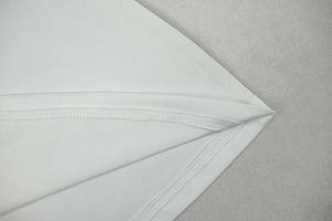 Detailed macro view of white knitted fabric showing precise double-needle overlock stitching