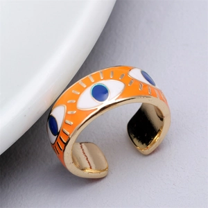 Detailed close-up of orange enamel evil eye ring with adjustable golden band