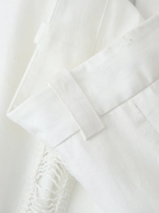 Gros plan de la taille du pantalon blanc avec passants et détails de glands décoratifs