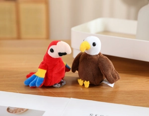 Detail of plush parrot and eagle finger puppets on a rustic wooden surface