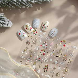 Detail of 3D embossed Christmas nail stickers featuring gold trees and festive patterns