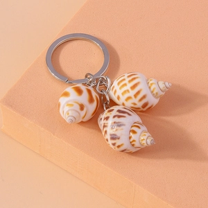 Nautical keychain featuring natural white sea shells with brown spirals on orange background