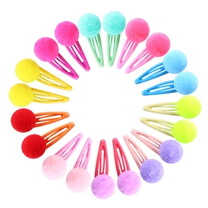 Close-up of colorful plush ball hair clips for girls arranged in a vibrant circular pattern