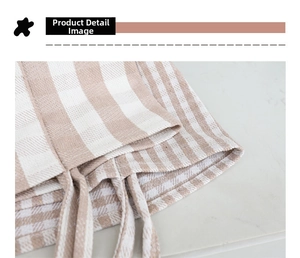 Detailed close-up showing the stitching and natural texture of the plaid canvas tote bag