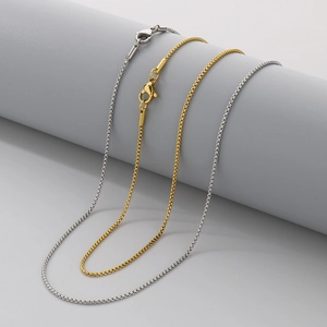 Detailed view of silver and gold stainless steel box chains with lobster clasps