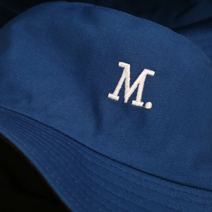Dettaglio cappello pescatore in cotone blu navy con ricamo premium della lettera M