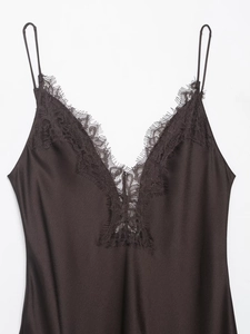 Detail eines dunkelbraunen Satin-Kleids mit zarter Spitze und seidiger Textur