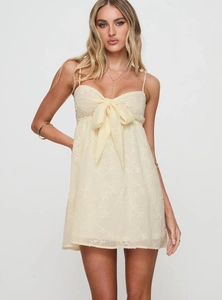 Detail of elegant lace mini dress featuring delicate embroidery and front bow accent