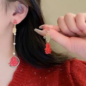 Detail of red and gold Chinese New Year earrings with festive Fu and Xi characters