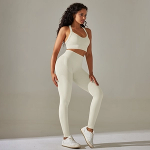 Detail view of seamless ribbed waistband and cross-back sports bra in cream white fabric