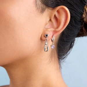 Silver paperclip heart earrings with pink and white crystals on a female model