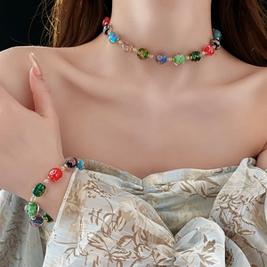 Detailed view of colorful glass bead necklace and bracelet with intricate floral patterns