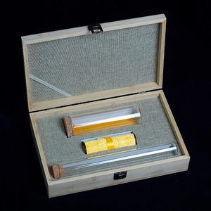 Premium bamboo gift box with glass vials and silk scroll on elegant black background