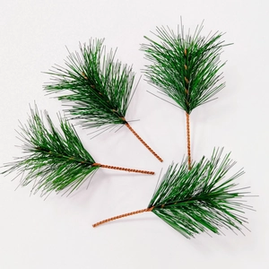 Detailed close-up of four artificial green pine needle branches for Christmas decoration