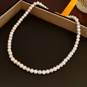Detailed macro view of white and pink pearls in a luxury jewelry box with gold trim