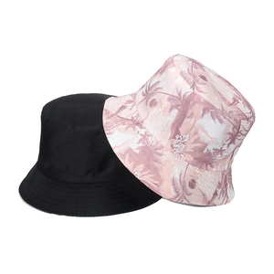 Reversible bucket hat with black side and tropical palm tree print for outdoor sun protection