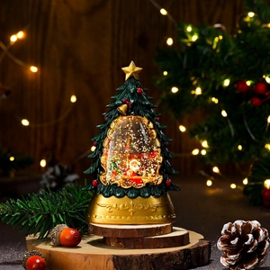Detail of Christmas tree snow globe with Santa Claus scene and golden base on wood