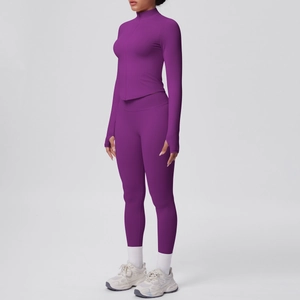 Dettaglio del set yoga viola con asole per i pollici, top con zip e leggings a vita alta