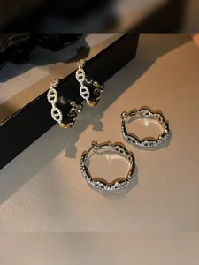 Macro shot of gold and silver chain link earrings with white cubic zirconia pavé