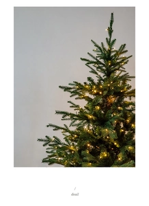 Detailed macro view of dense artificial pine needles with warm white LED string lights