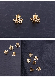 Makro-Detail von goldene Blumen-Ohrstecker mit Schmetterlings-Verschluss auf dunklem Leder