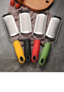 Flat lay of colorful stainless steel cheese graters on marble surface with lemon