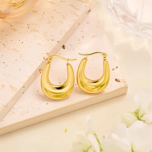 Détail de boucles d'oreilles créoles en forme de U en acier plaqué or 18 carats sur pierre