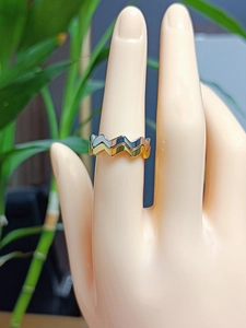 Makroaufnahme minimalistischer Wellenring in Silber und Gold an einem Fingermodell