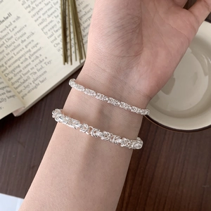 Close-up of dual silver Byzantine chain bracelets with 925 sterling silver textures