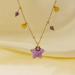 Detail showing the light purple star pendant and beaded gold chain on silk background