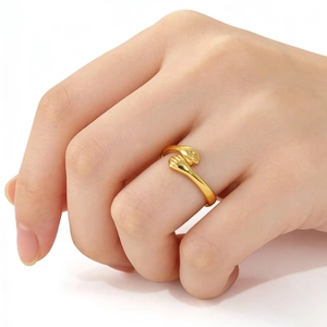 Detail of gold hugging hands ring on model's finger with polished metal finish