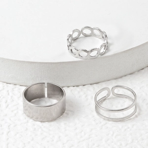 Detailed view of a 3-piece silver titanium steel ring set with adjustable open designs