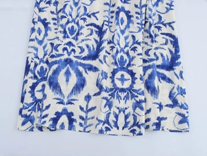Detailansicht des blau-weißen Blumenmusters am Saum eines Kleides im Urlaubsstil