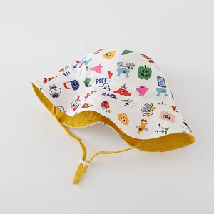 Close-up of kids cartoon bucket hat with colorful monster prints and adjustable yellow strap