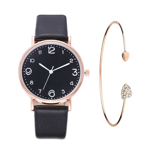 Detail view of stylish rose gold watch with black leather strap and heart-shaped bracelet