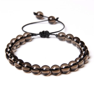 Macro detail of polished brown tiger eye stone beads on adjustable woven cord bracelet