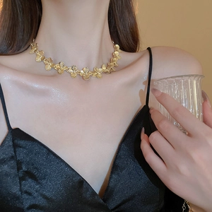 Close-up of gold tone floral necklace on model showing delicate petal joint details