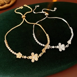 Dettaglio di bracciali a fiore regolabili con zirconi in finiture oro e argento