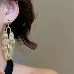 Detailed close-up of French vintage gold fringe earrings worn to show elegant drape and length