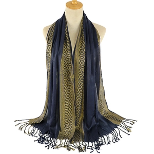 Detail of navy blue shawl with golden ethnic pattern and fringe on a mannequin