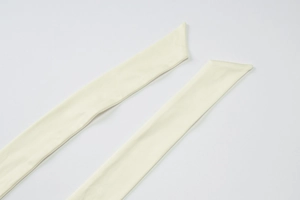 Close-up detail of beige mesh fabric straps with high-quality textured stitching on long dress