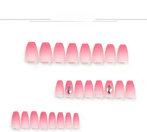 Close-up of pink gradient press-on nails with rhinestone accents in coffin shape