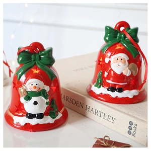 Close-up of red Christmas bell ornaments with Santa and Snowman on vintage books